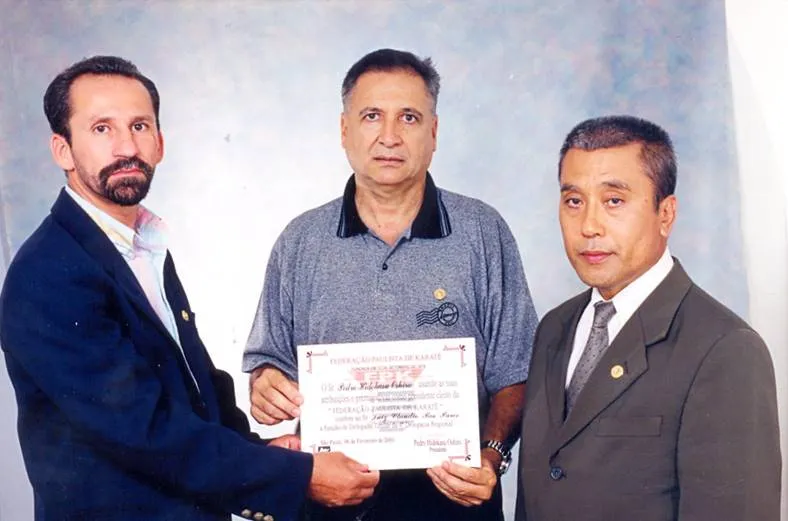 Prof. Ivon Dedé, Prof. L. C. Pares com o diploma de Delegado Adjunto da 4ª Região Esportiva (2004–2005) e Sensei Oshiro, presidente da Federação Paulista de Karate